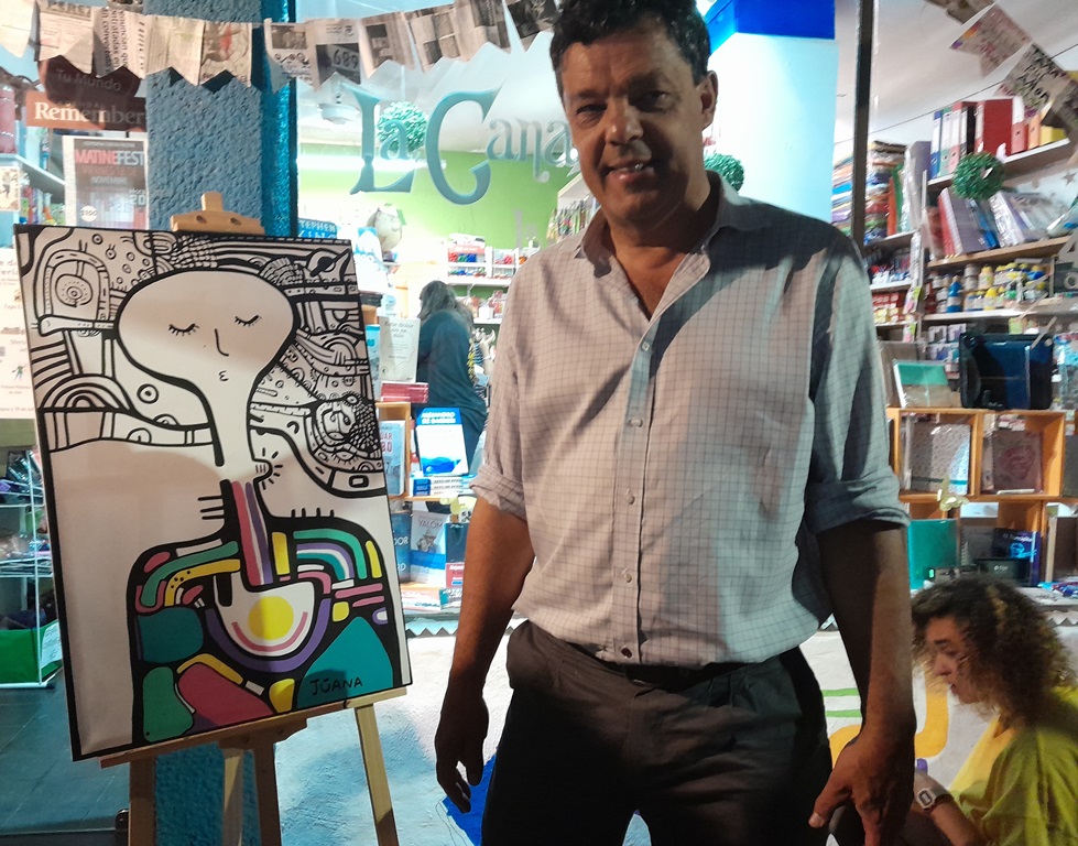 Pablo Pucheu junto a la obra de Juana Agustina, frente a la librería La Canasta